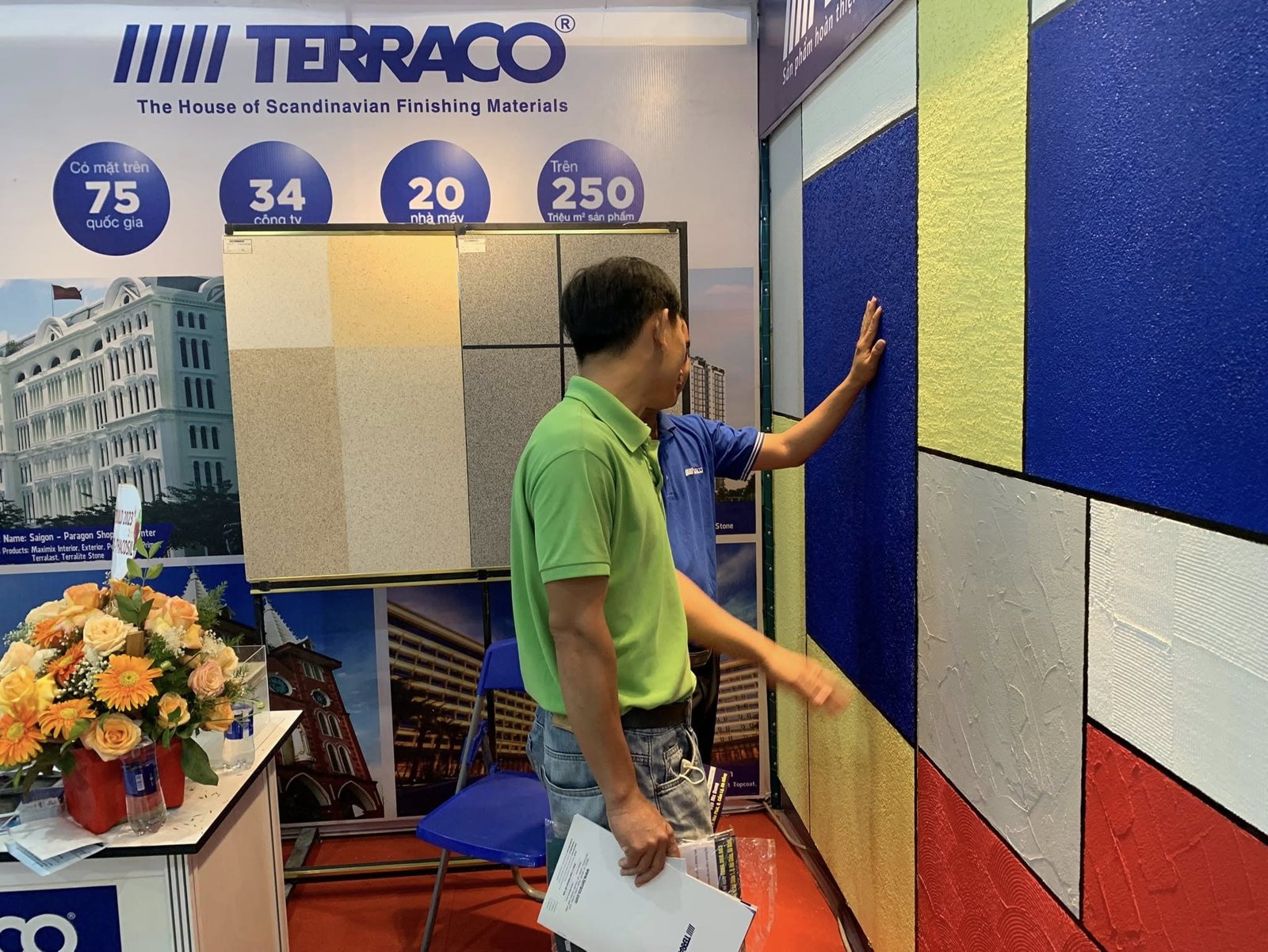 Khách hàng chạm tay vào mẫu tường hiệu ứng Terraco